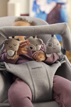 
                        
                          Load image into Gallery viewer, Baby in a bouncer with plush toys and 'BabyBjörn' branding.
                        
                      