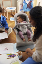 
                        
                          Load image into Gallery viewer, Child in a baby bouncer with another child and an adult in a home setting.
                        
                      