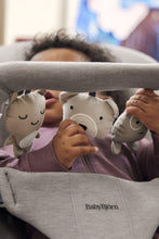 
                        
                          Load image into Gallery viewer, Child playing with plush toys in a BabyBjörn bouncer
                        
                      
