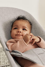 
                        
                          Load image into Gallery viewer, Baby in a gray Bouncer Bliss lying on a light surface
                        
                      