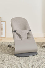 
                        
                          Load image into Gallery viewer, Gray baby bouncer chair on a carpeted floor with a light-colored wall in the background
                        
                      