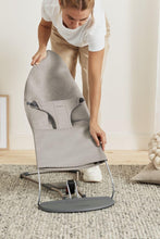 
                        
                          Load image into Gallery viewer, mum adjusting a gray bouncer cover with a cushion on a carpeted floor.
                        
                      
