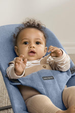 
                        
                          Load image into Gallery viewer, Baby in a blue baby bouncer with a neutral background
                        
                      