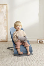 
                        
                          Load image into Gallery viewer, toddler sitting on a blue bouncer holding a stuffed animal in a room with a light-colored wall and framed picture.
                        
                      